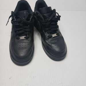  all-black Nike Air Force 1 Low sneakers, featuring a full-grain leather upper
